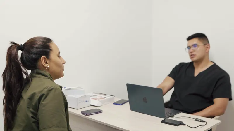 El profesional de QuiroFit escucha a una mujer durante una conversación en su consultorio