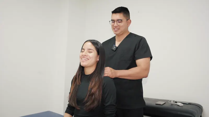 El profesional de QuiroFit realiza trabajo manual en cuello y hombros de una mujer sentada