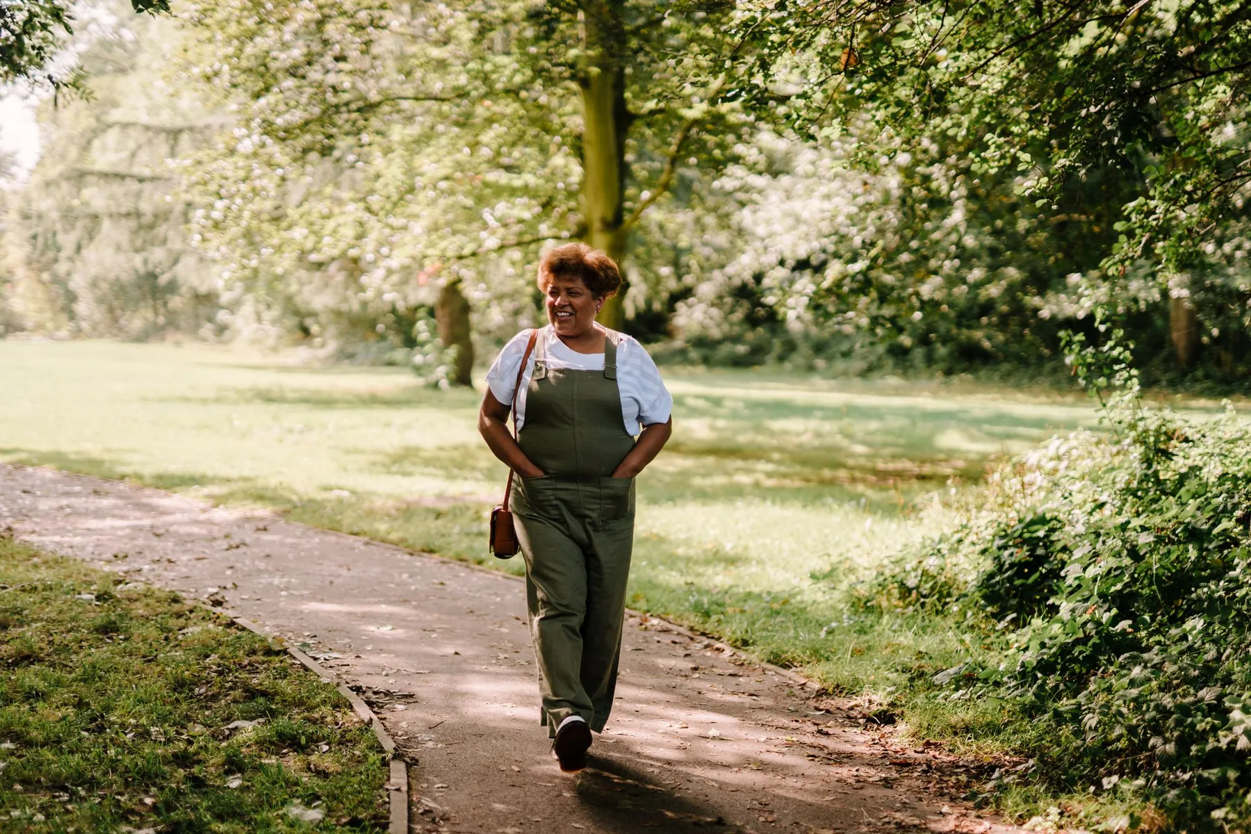 Una mujer disfruta una caminata en un parque