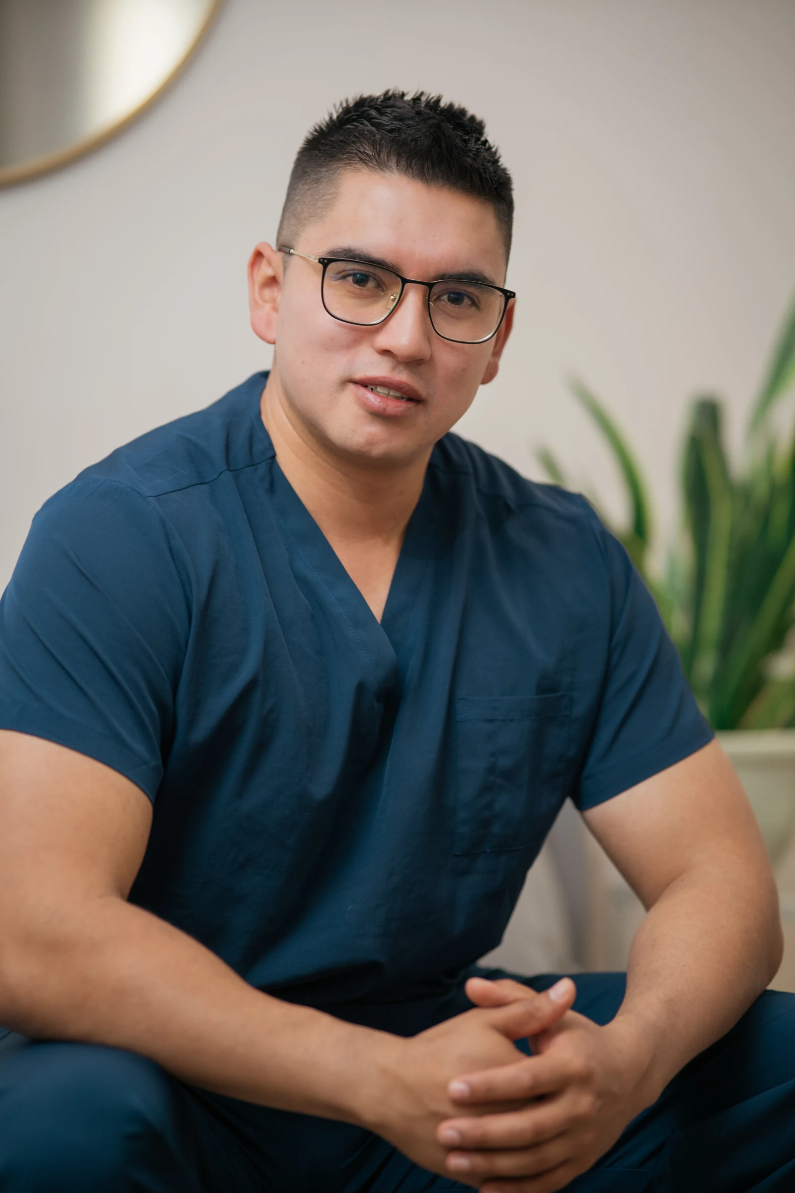 Retrato original del profesional de QuiroFit sentado, con uniforme azul